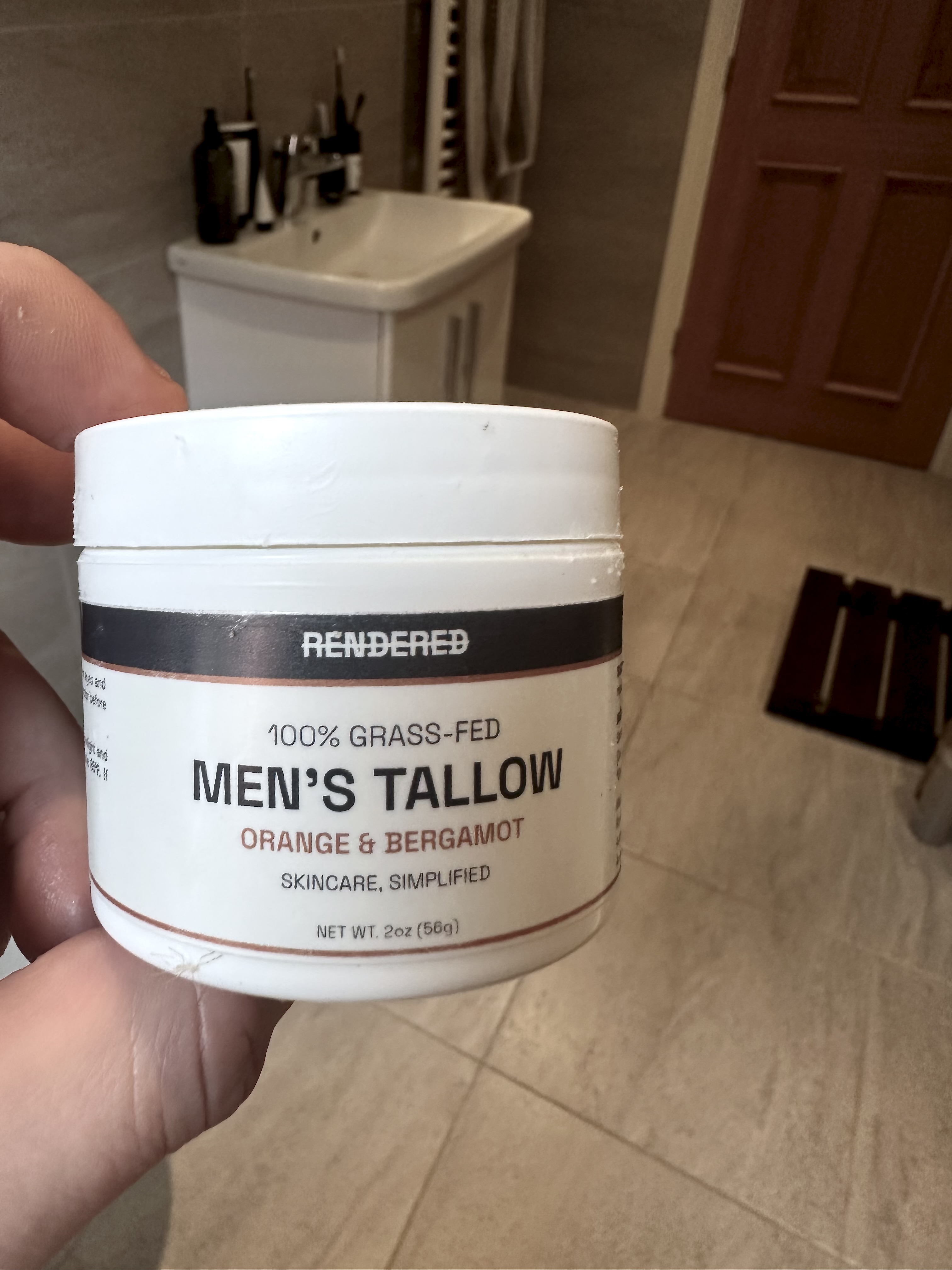 Michael holding a jar of Rendered 100% grass-fed Men's Tallow, orange and bergamot